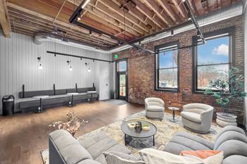 A room with a brick wall and a wooden ceiling.at Plant 1 Lofts, Iowa, 50208